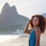 portrait young black afro woman on the beach with mountain in the background in Ipanema Brazil